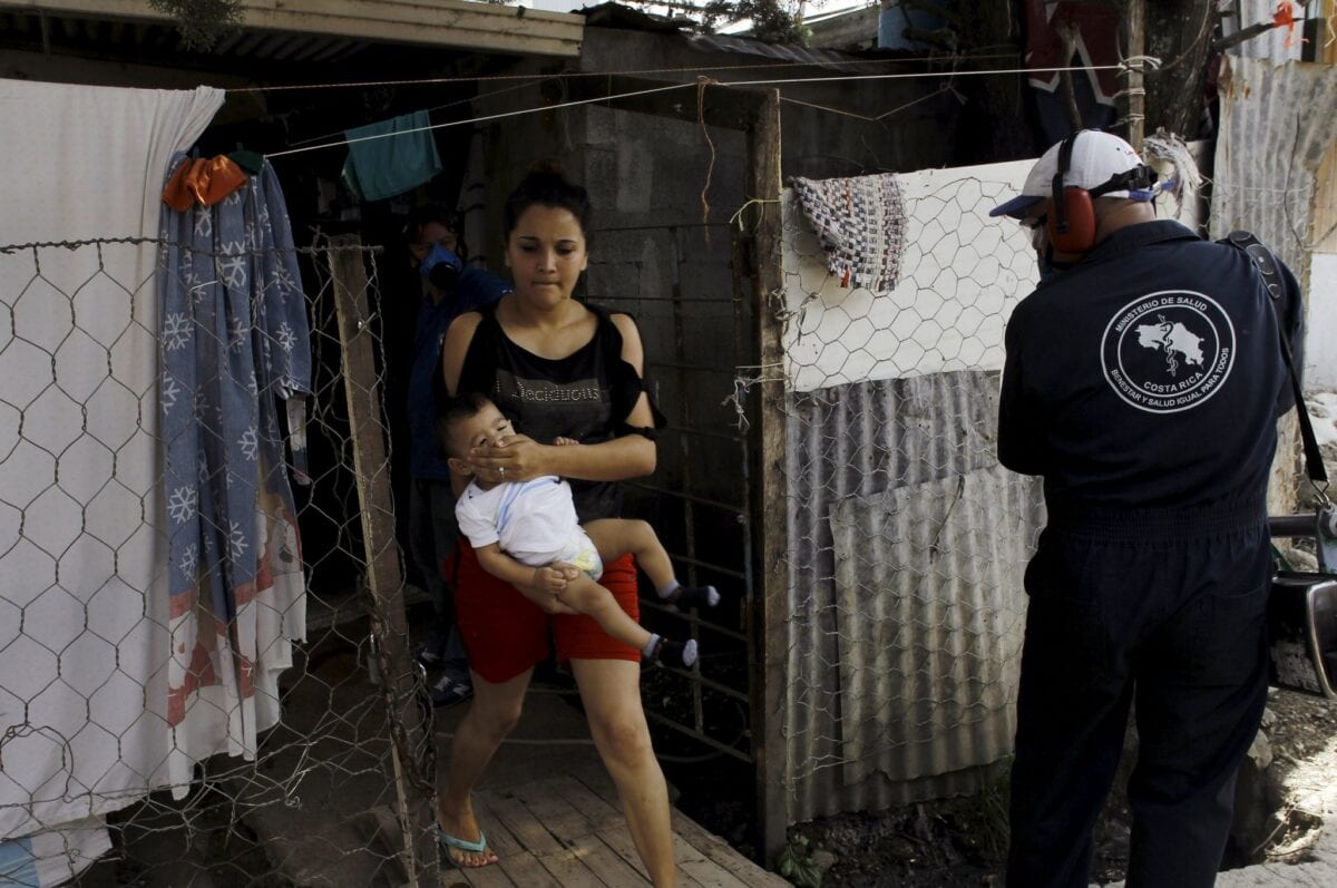 الوقاية من مرض فيروس زيكا , صور واعراض ومعلومات 6 A woman covers the nose to her son as a health worker fumigates La Carpio slum to help control the spread of the mosquito-borne Zika virus in San Jose, Costa Rica, January 28, 2016. REUTERS/Juan Carlos Ulate